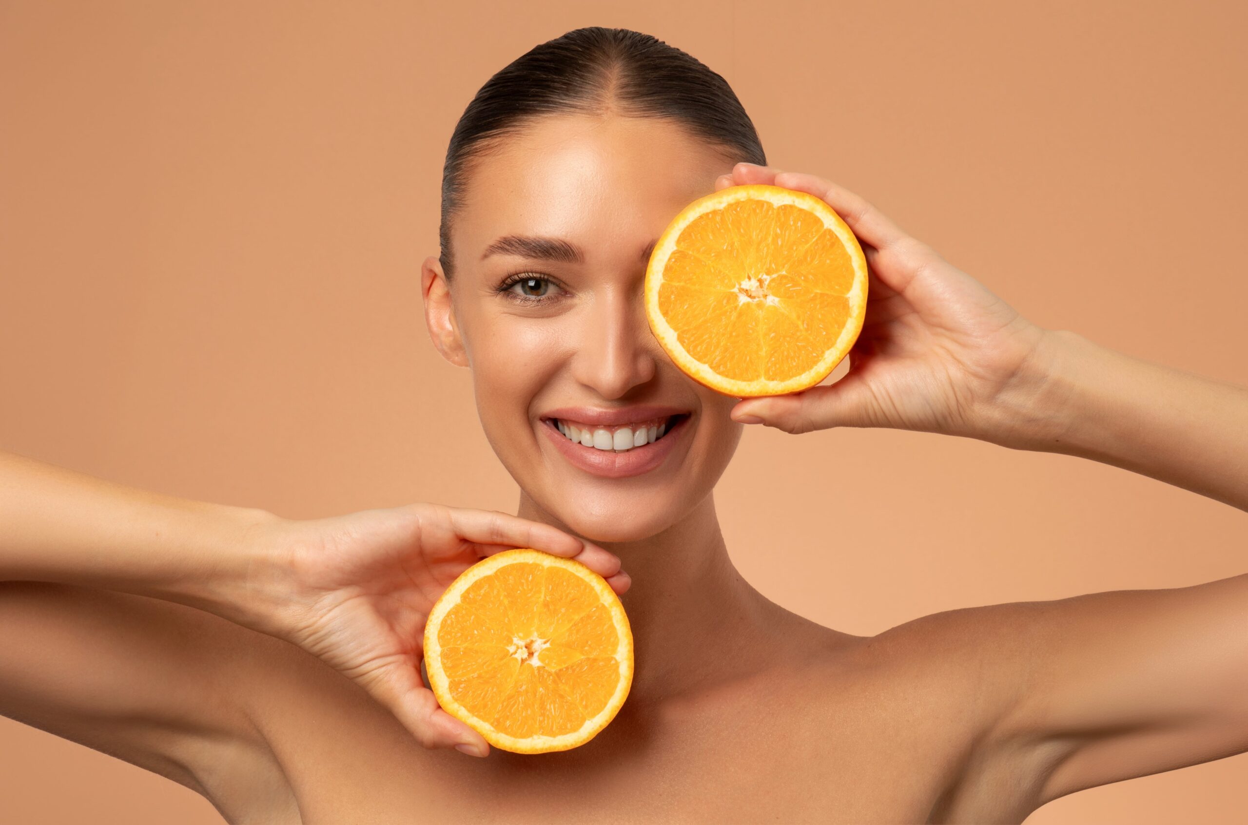 happy woman with oranges for skincare