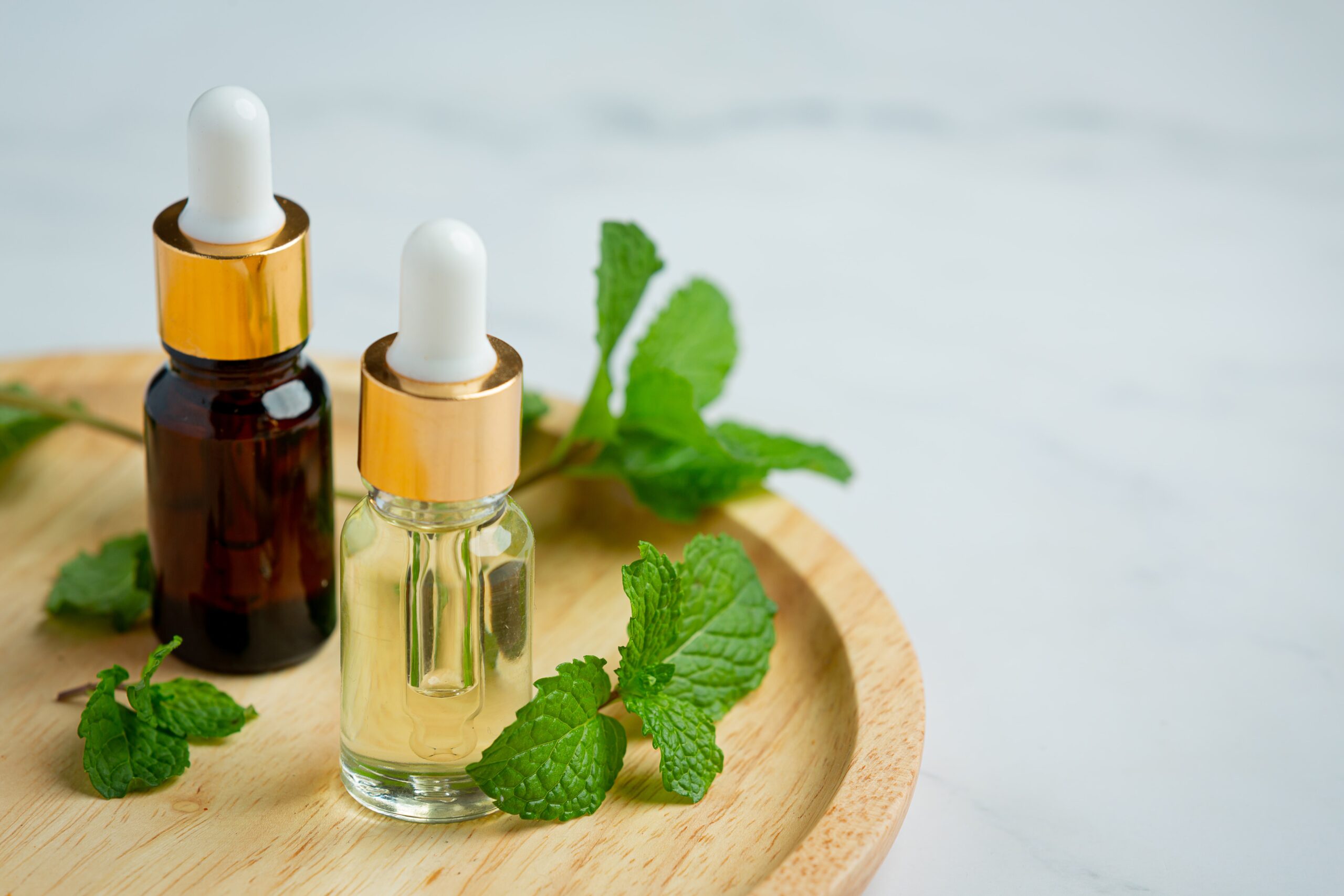 peppermint oil in bottles with fresh mint on the side