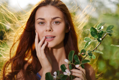 beautiful brown-haired lady in nature, holding a plant