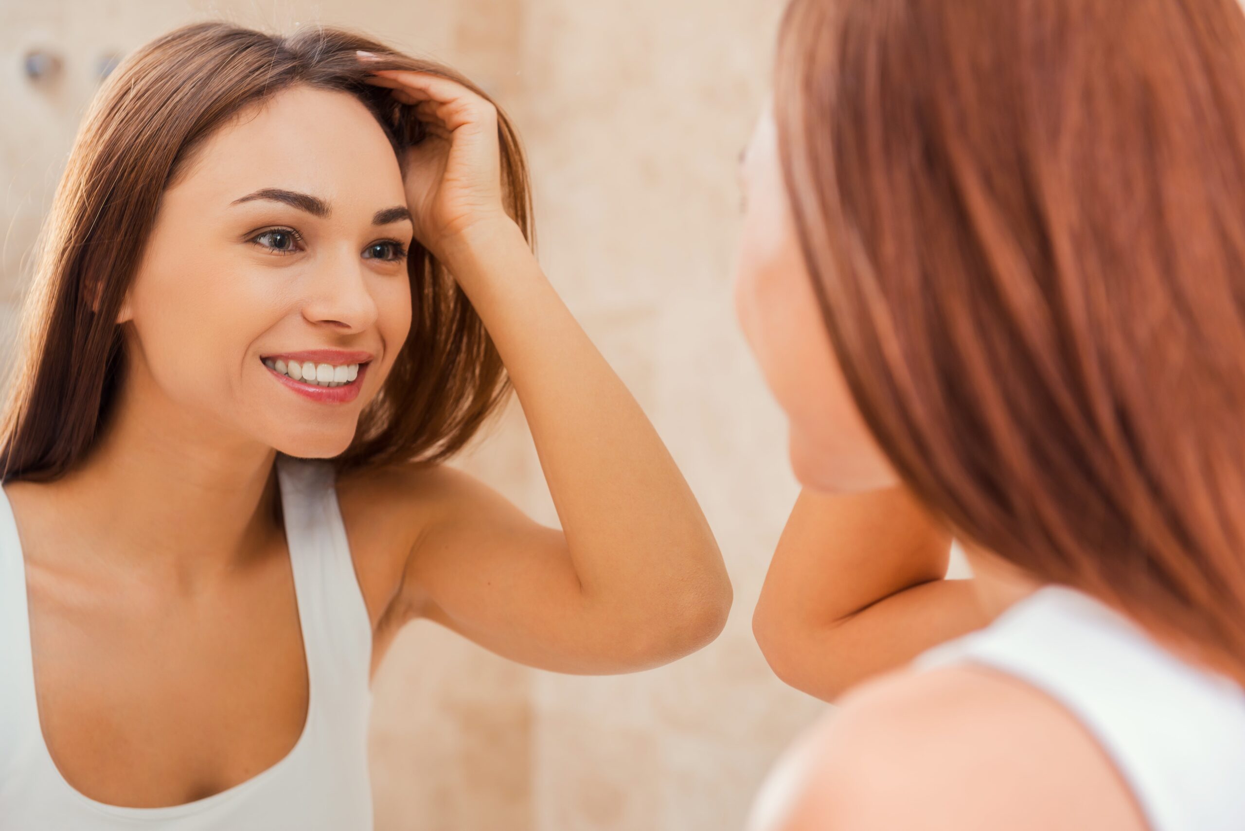 woman with lovely hair and skin looking in the mirror